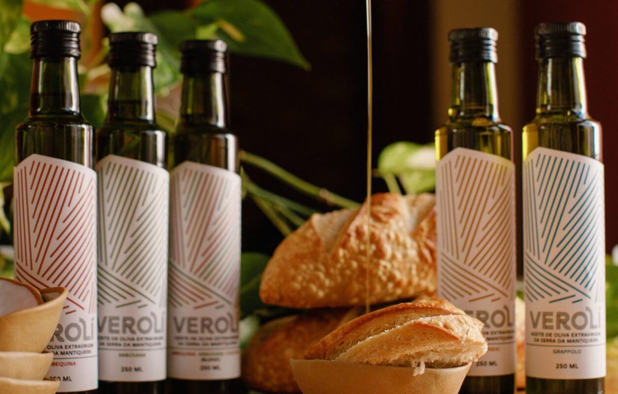 Garrafas das cinco variedades de azeite Verolí servidas à mesa com pão artesanal